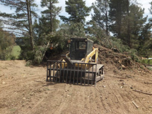 Land clearance Skidsteer with stickrake and stockpile